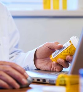 A doctor holding a container of prescription medication