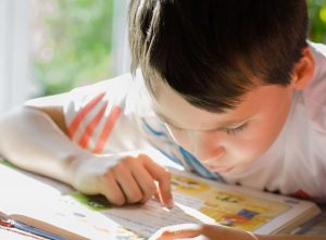 A young boy concentrating on reading a book