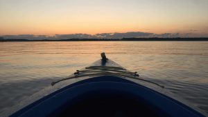 A panoramic view of a lake from the bow of a small boat