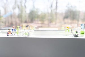 A series of children's toys sitting on a window sill