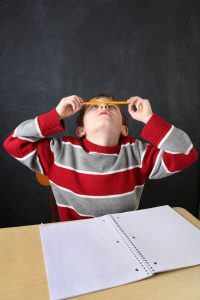 Bored student balancing a pencil on his nose