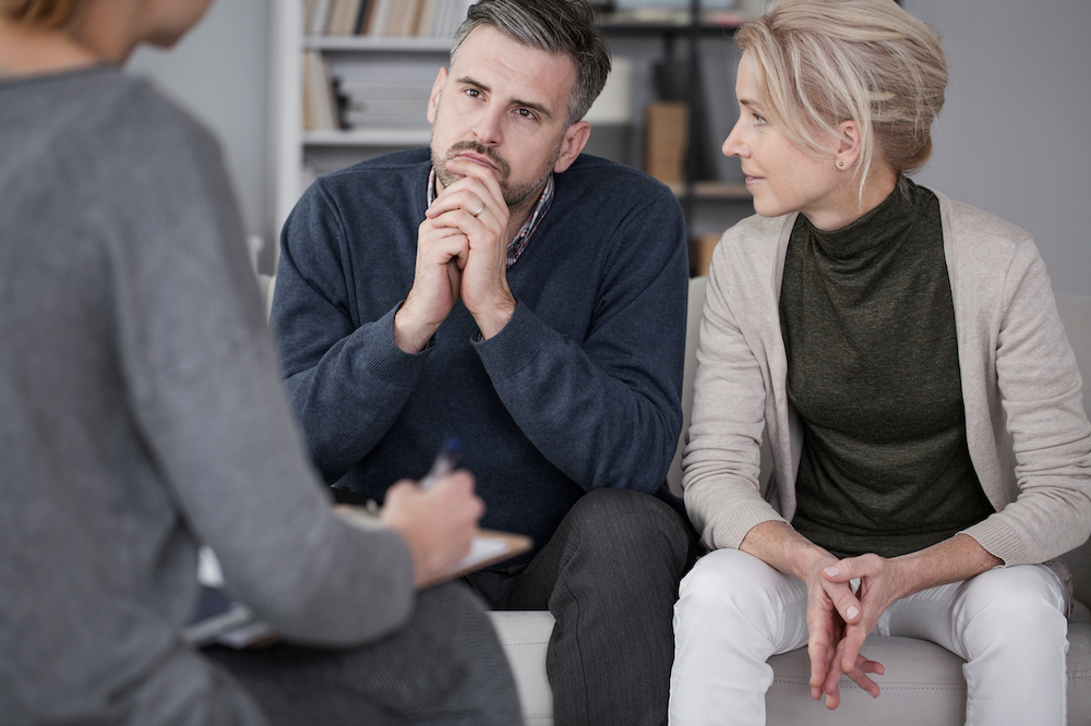 Wife Supporting Her Husband In Therapy With The Man Listening