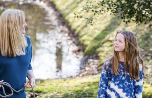 A young girl taking to a therapist in an outdoors session