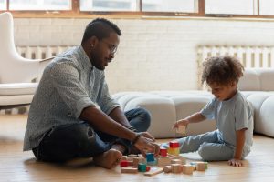 Afro American father and son playing on the floor