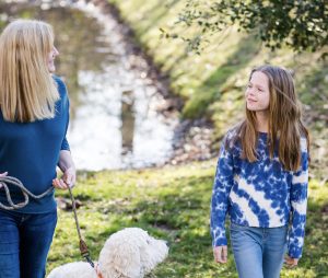 A young girl doing a therapy session with therapist and emotional support dog